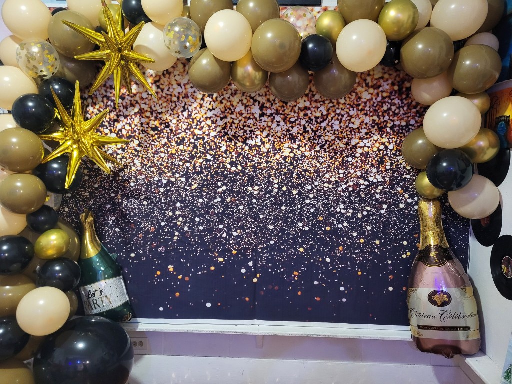 Elegant party backdrop with gold balloons, sparkling sequin wall, and themed event décor setup created for customized paint parties, birthdays, girls nights, bridal showers, and special event experiences in Lafayette Louisiana.