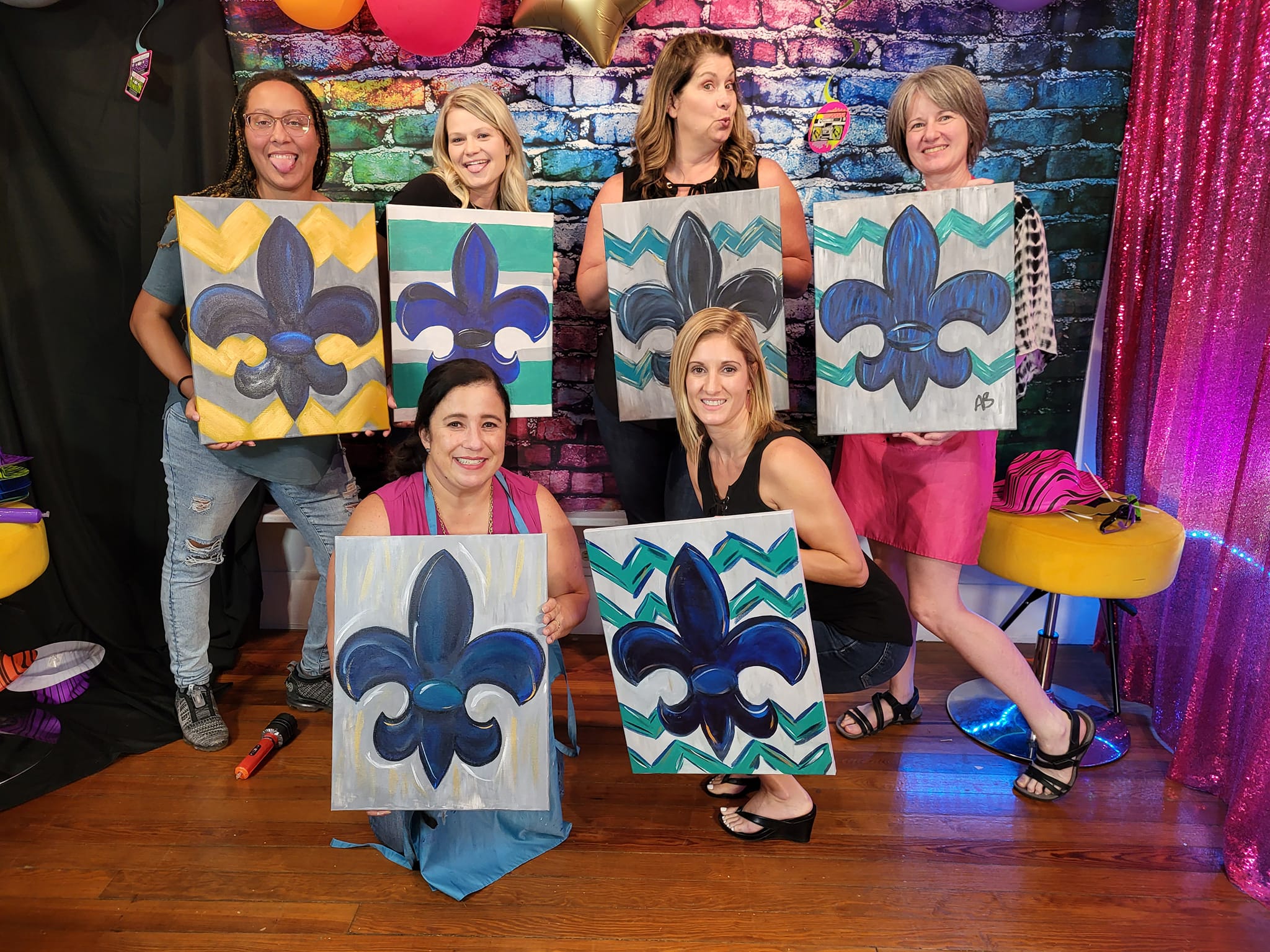 Guests showing off their paintings at a Lafayette paint party.